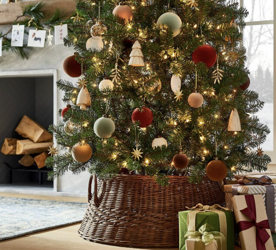 A brown rattan Christmas tree base secured around the base of a Christmas tree