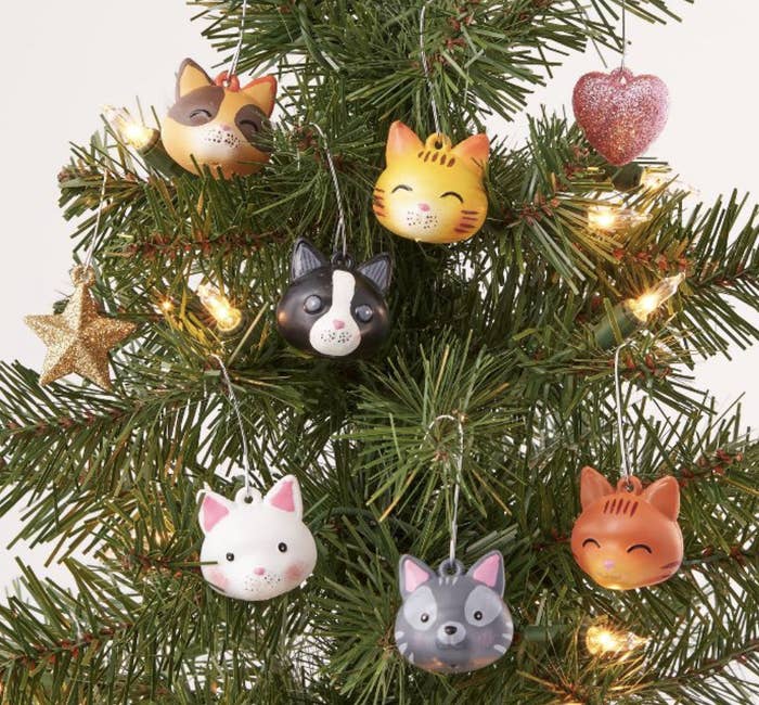 A collection of plastic Christmas ornaments shaped like cute little cartoon cat heads