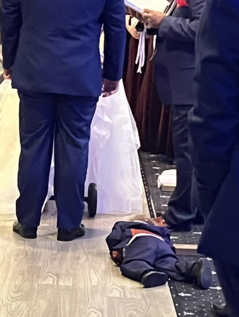 A boy sleeping on the floor during a wedding