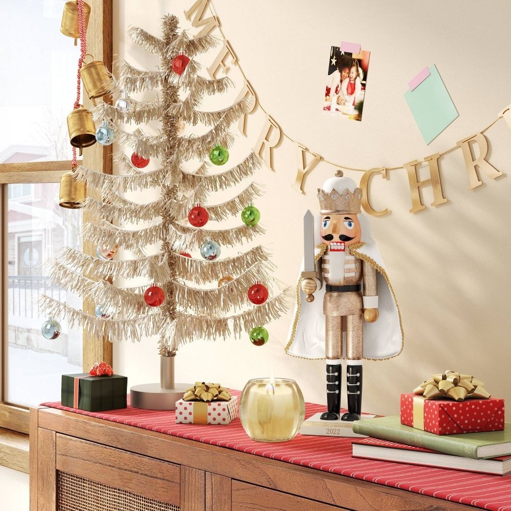 the tinsel tree atop a decorated console