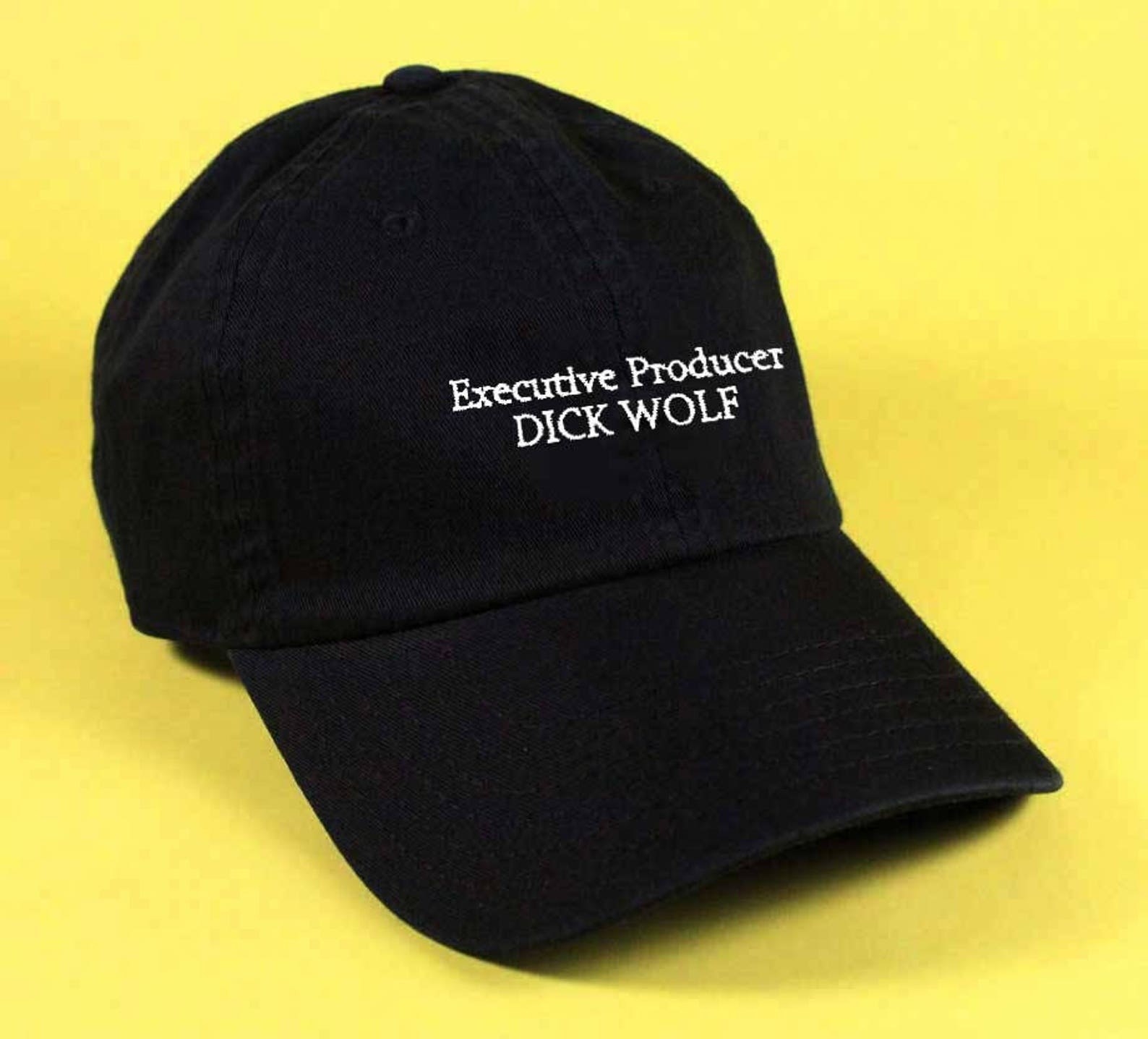 A black baseball hat with &quot;executive producer Dick Wolf&quot; embroidered on it