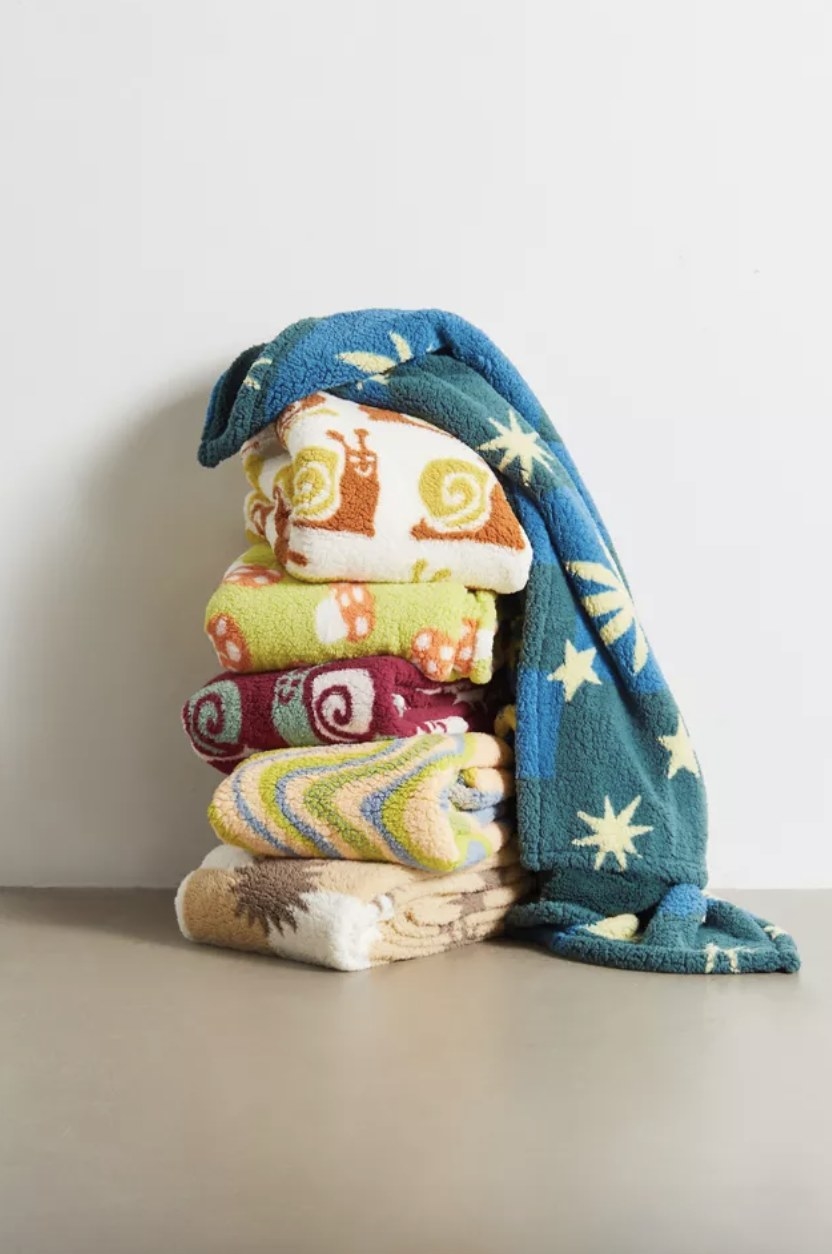 There&#x27;s a stack of various patterned blankets