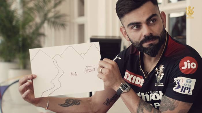 Virat Kohli holding up his drawing