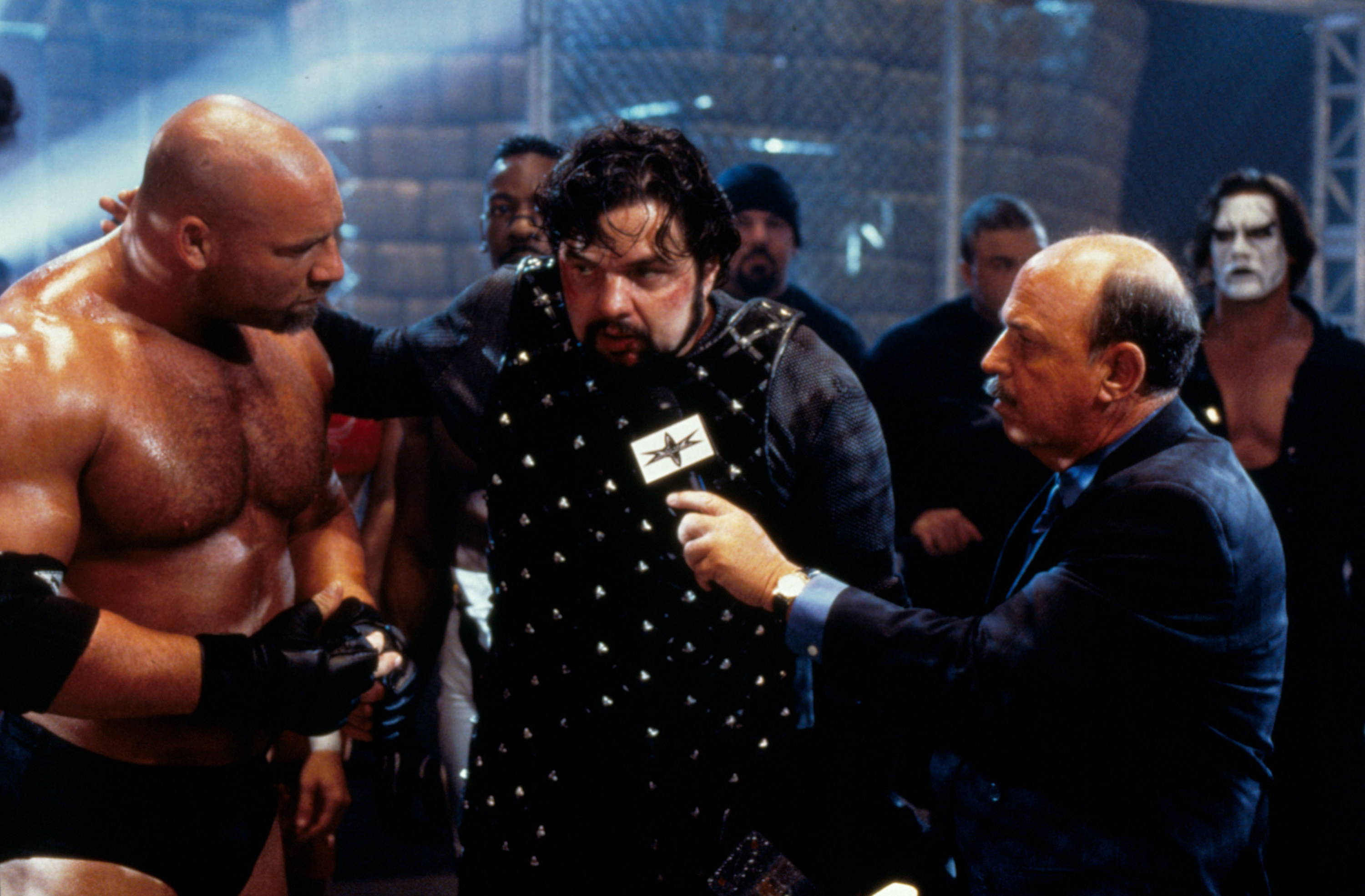 Goldberg and Mene Gene Oakerland hang around a medieval-themed pro wrestler