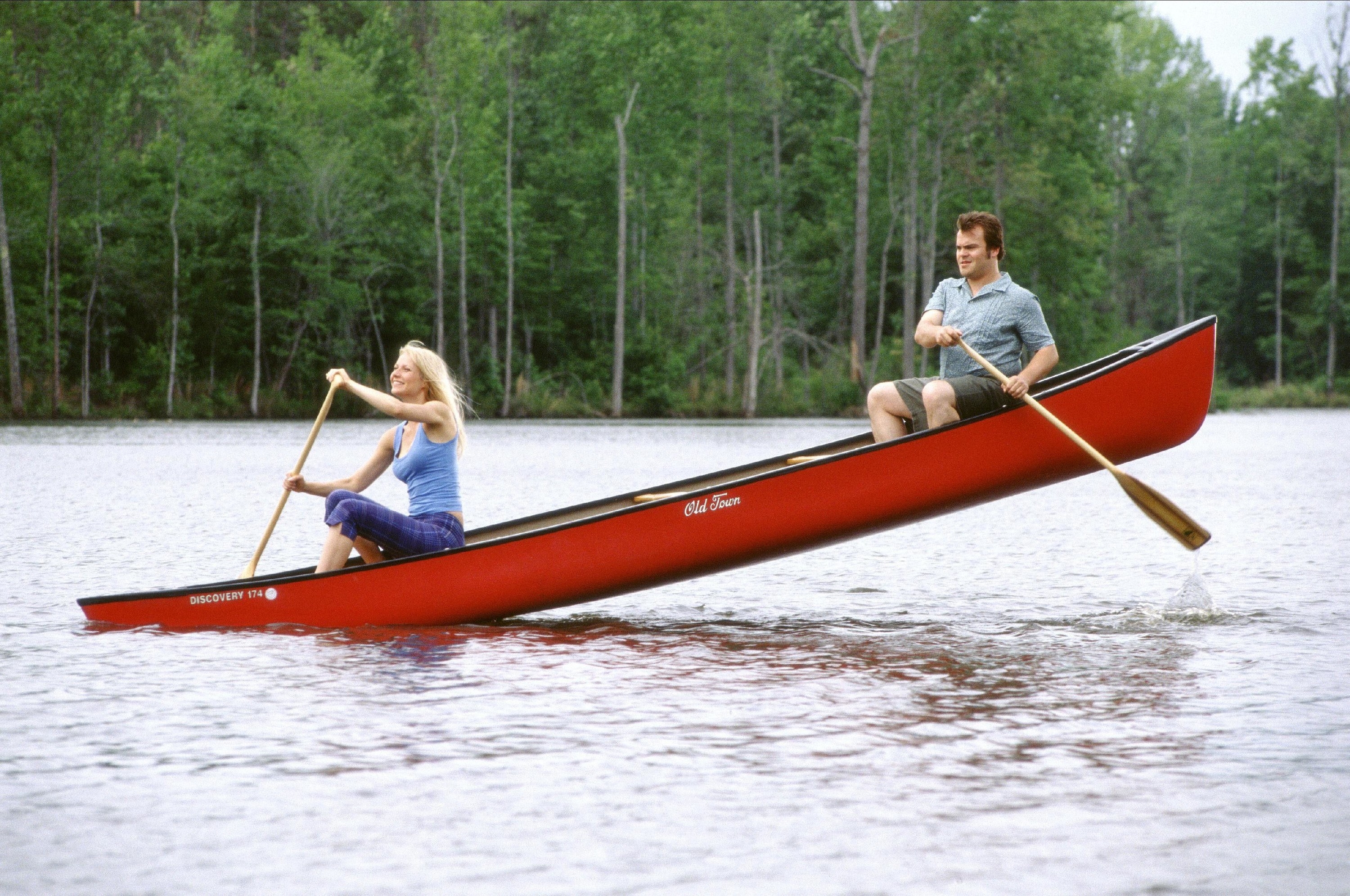 A woman paddles on a see-saw canoe with her boyfriend in the air