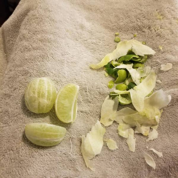 Three small pieces of peeled lime and pieces of rind on the side