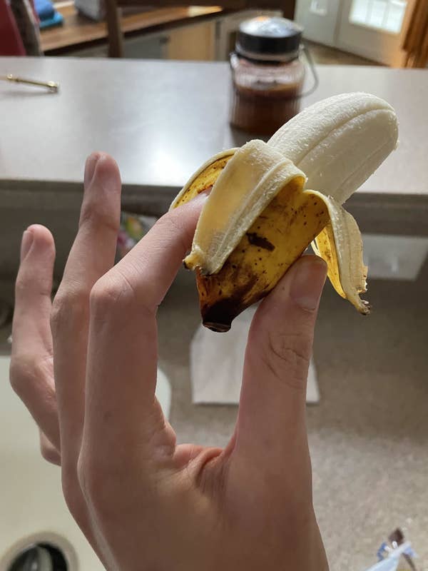 A mini banana half peeled