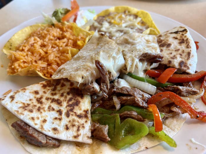 A plate of Tex-Mex food including a quesadilla and yellow rice.