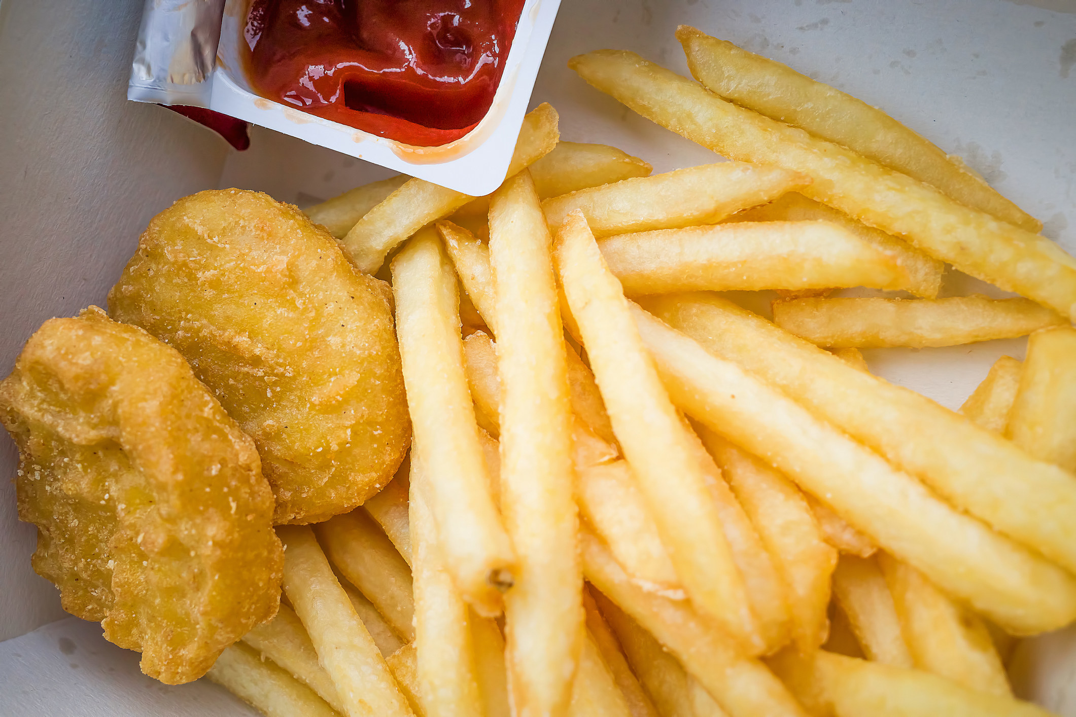 Chicken nuggets and fries with ketchup.