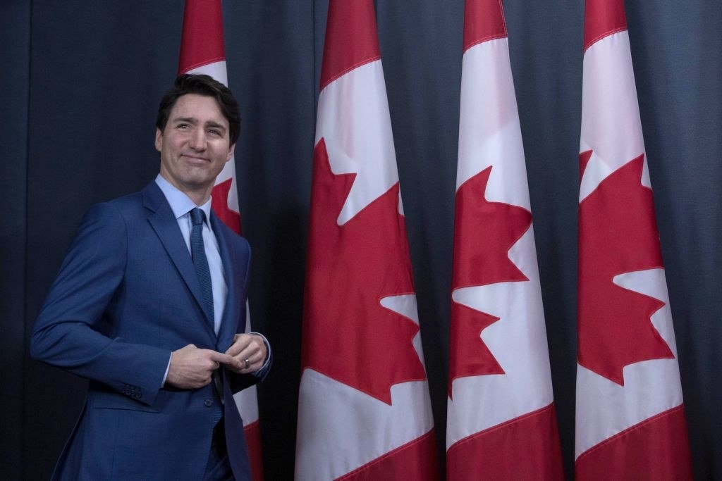 justin trudeau in front of canadian flags