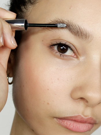 Model applies the gel to eyebrow