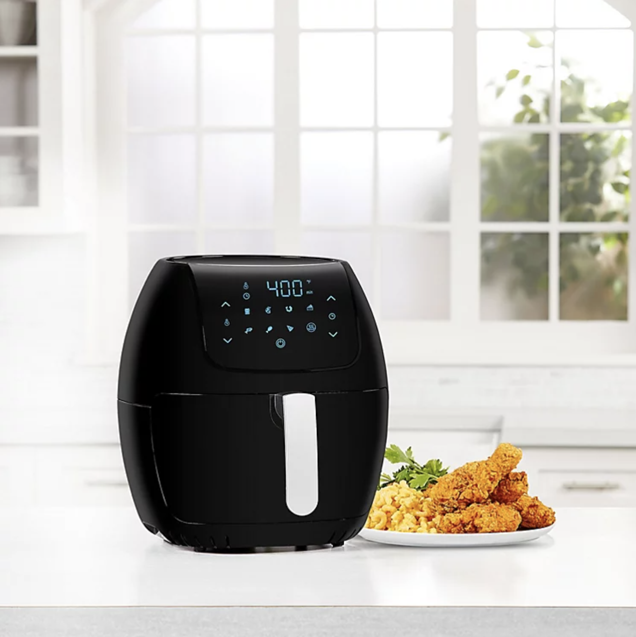 the black air fryer with food next to it
