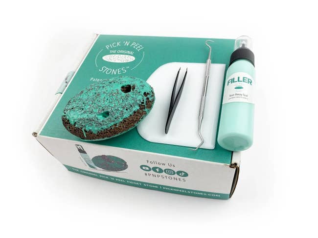 The Pick 'N Peel Stone kit with a bottle of filler, colorful rock, tweezers, and a scraping tool