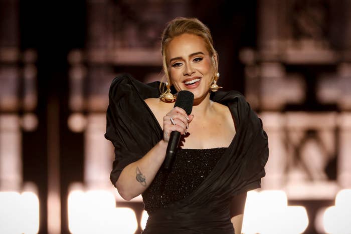 Adele holding a mic and smiling