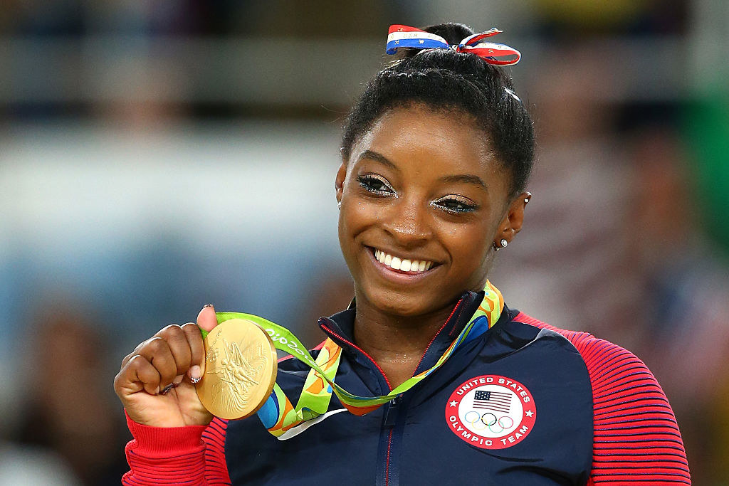 Simone holding up her gold medal