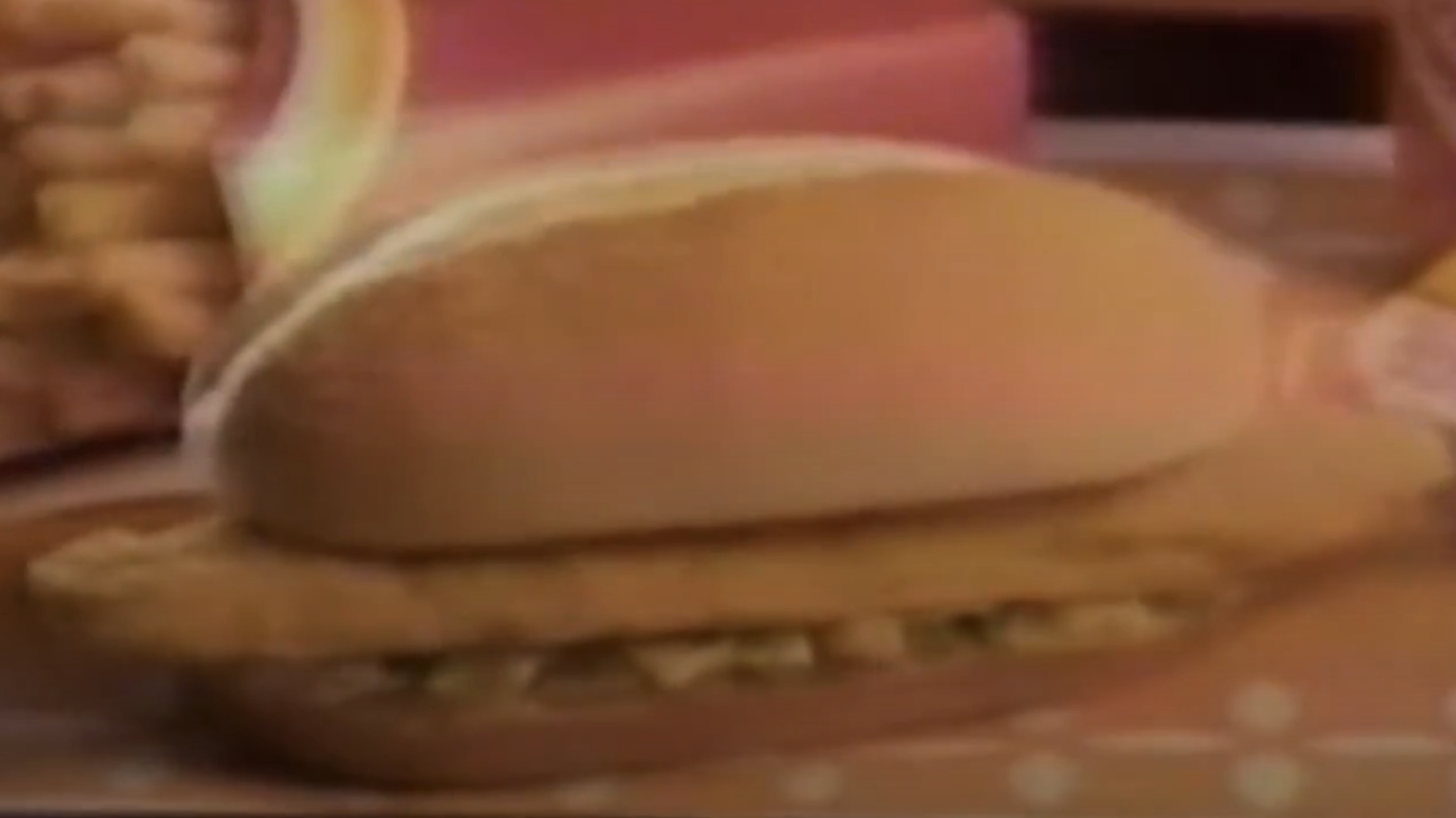 Blurry photo of a thin piece of fish in a bun