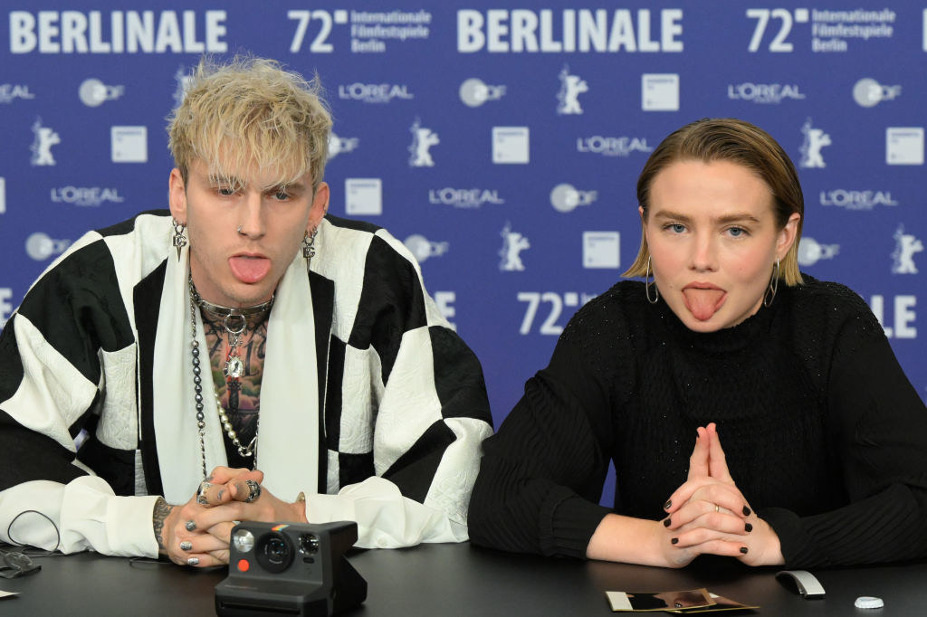 Colson sticking his tongue out as he sits next to an actress, who&#x27;s also sticking her tongue out, at the Berlinale film festival