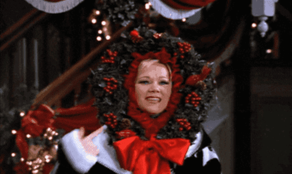 gif of character from sabrina show with a wreath on their head. after touching it the wreath lights up.