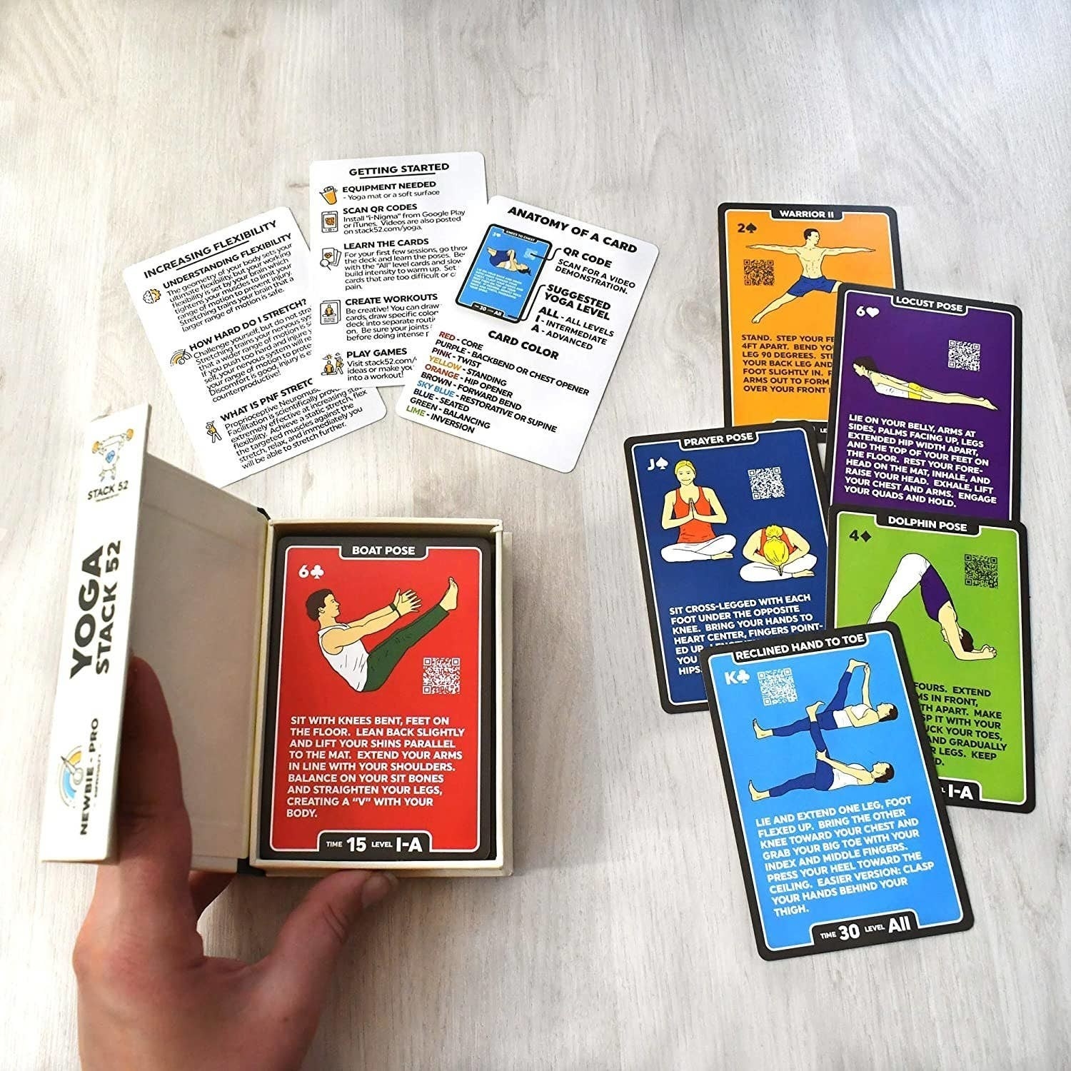a person holding the box of yoga cards open