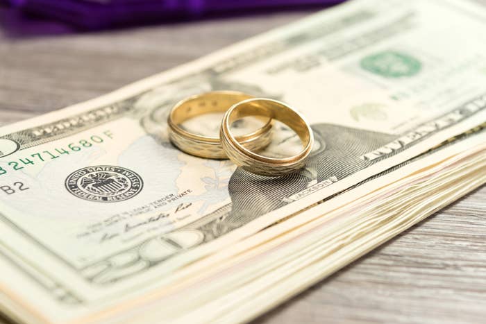 Wedding rings laying on a pile of money