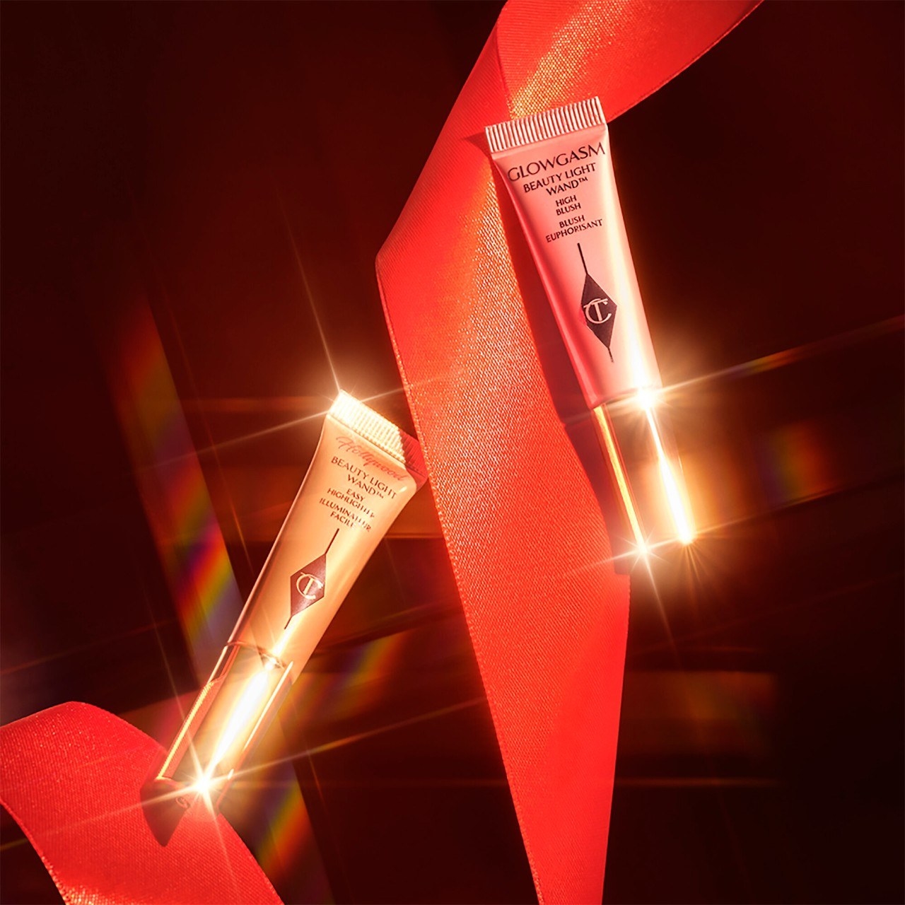 the two tubes of highlight against a dark backdrop surrounded by ribbon