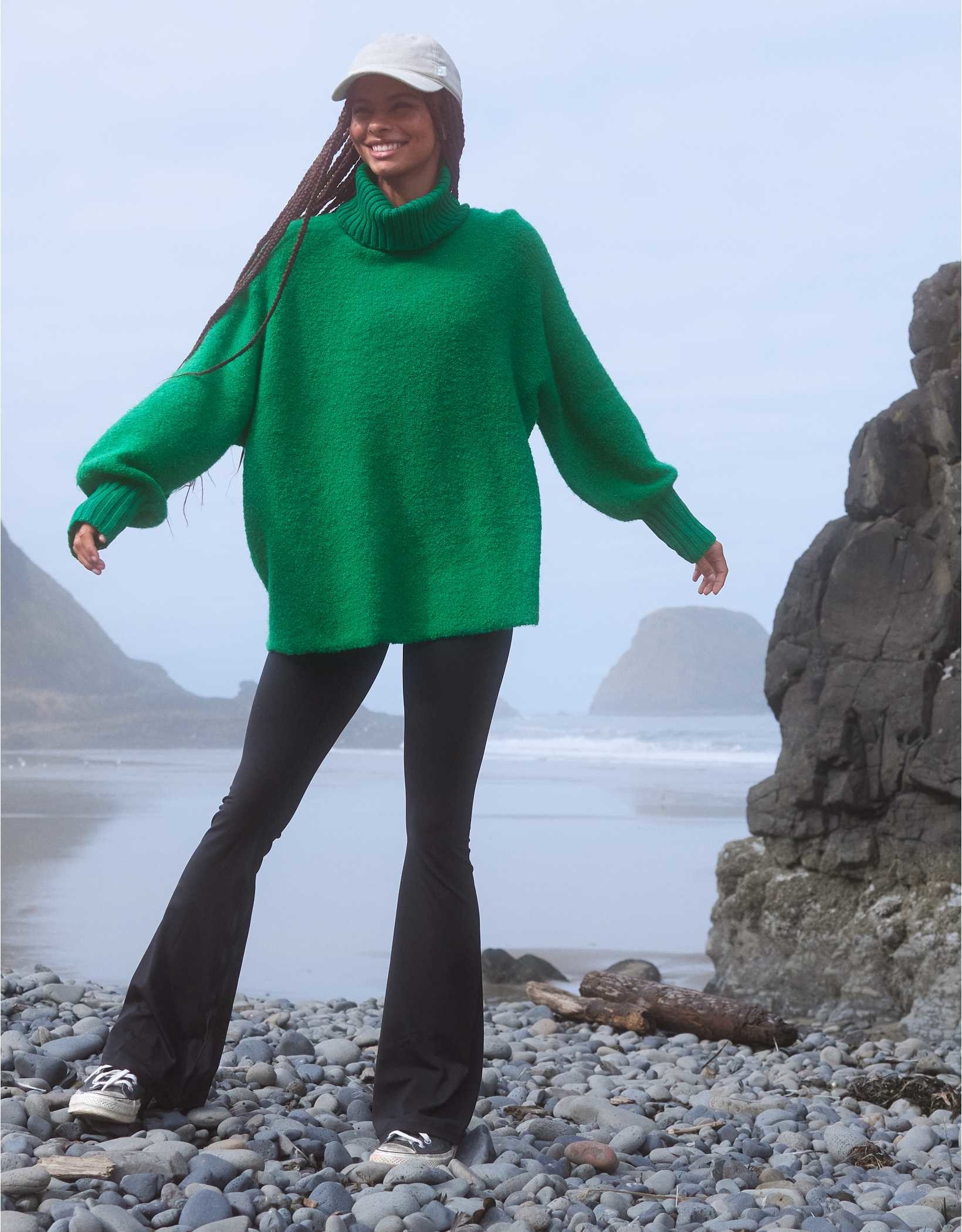 model in a kelly green long line turtleneck sweater