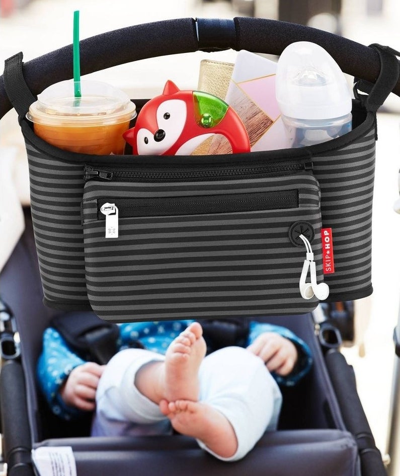 the black and gray stroller caddy with stuff inside