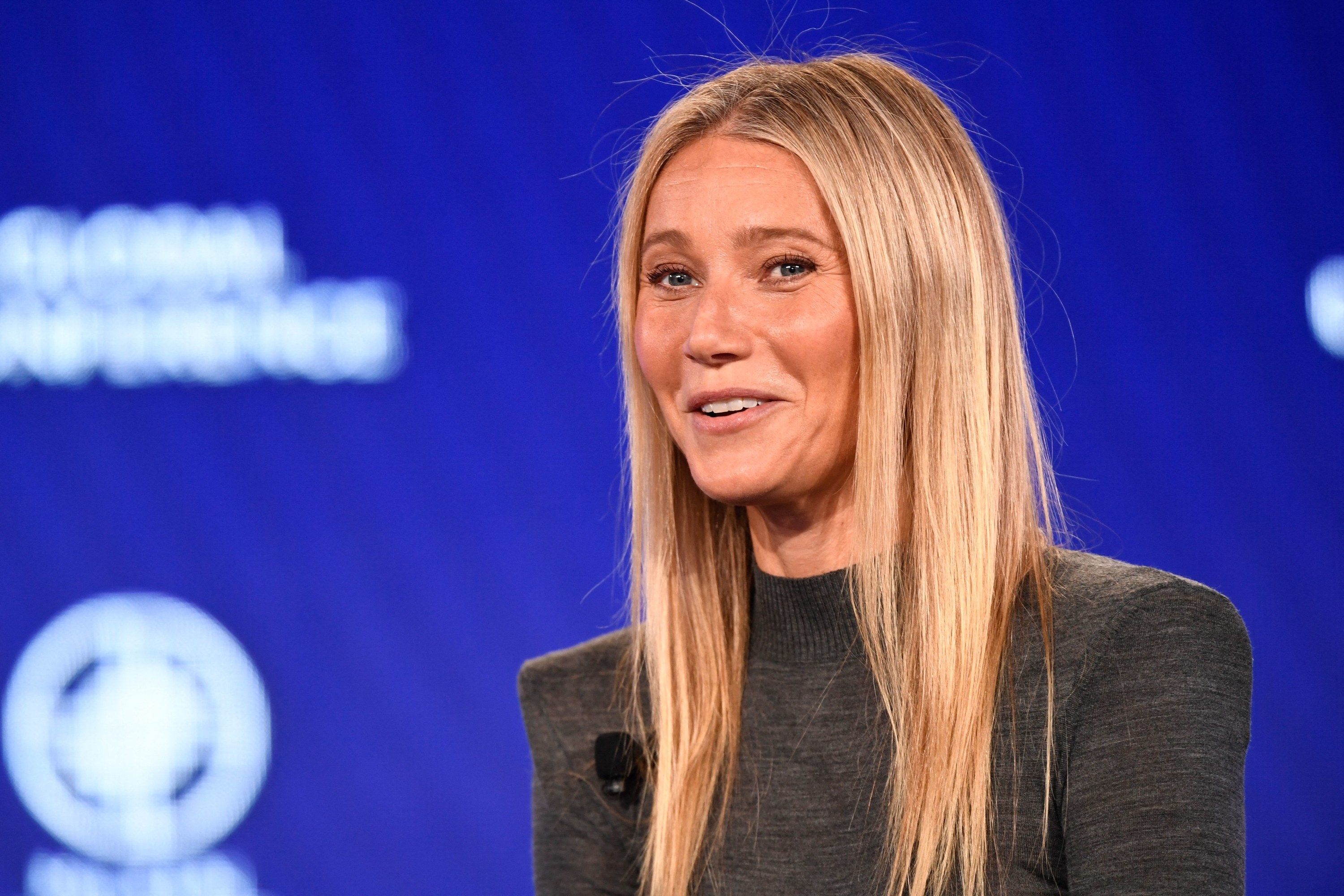 Gwyneth Paltrow laughing as she talks at an event