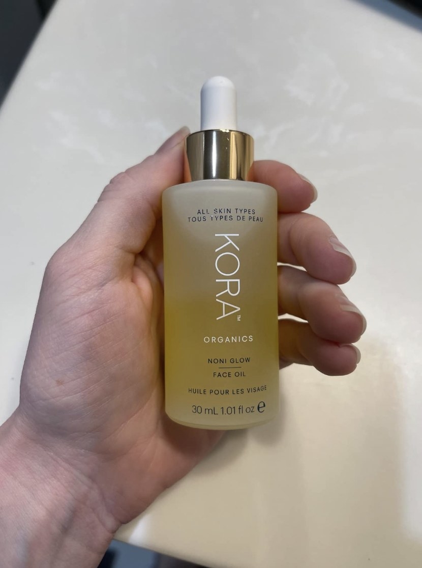 A person holding a bottle of face oil