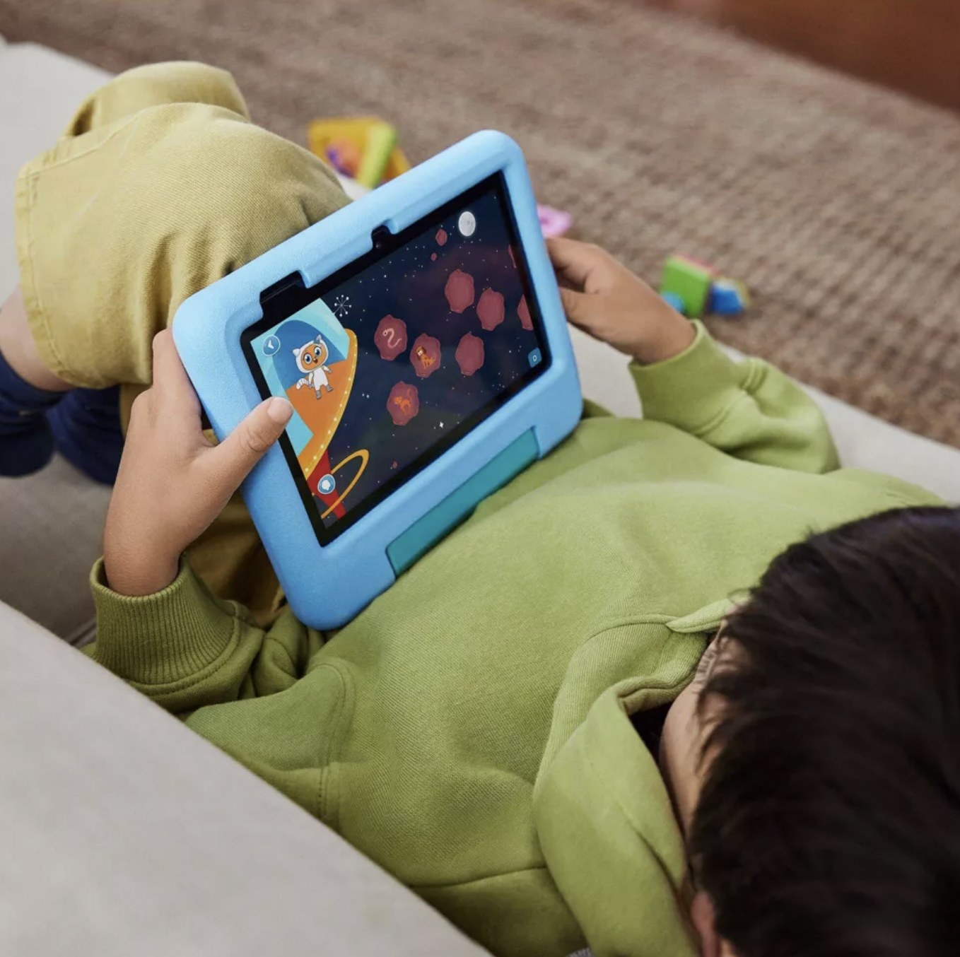 child playing game on the touchscreen blue tablet
