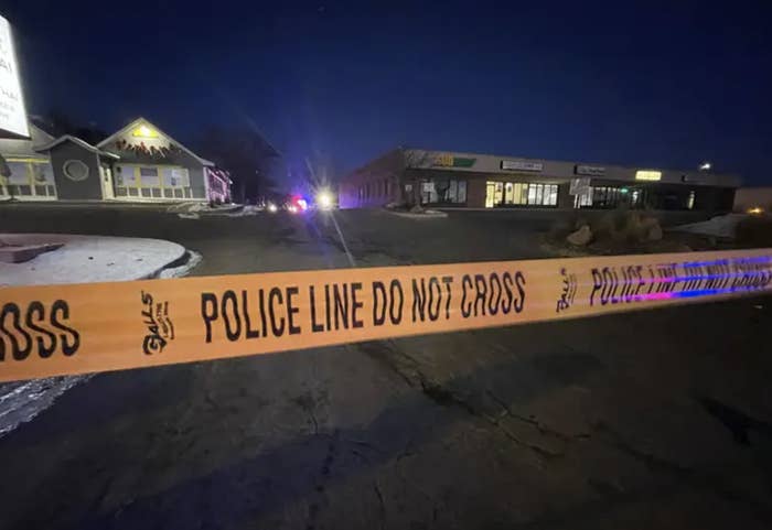 a stretch of caution tape that reads &quot;police line do not cross&quot; across a dark suburban night