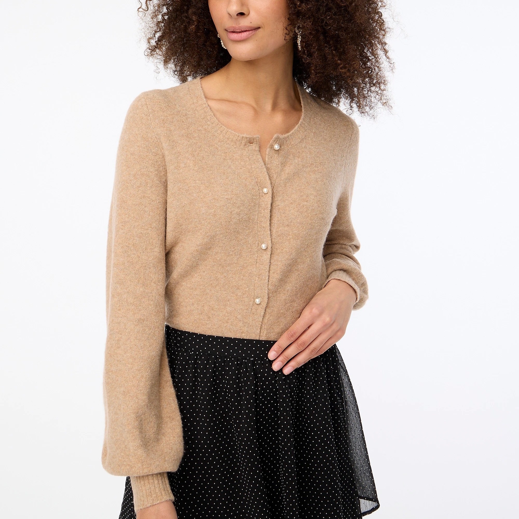 model in tan cardigan with puffed sleeves and pearl buttons