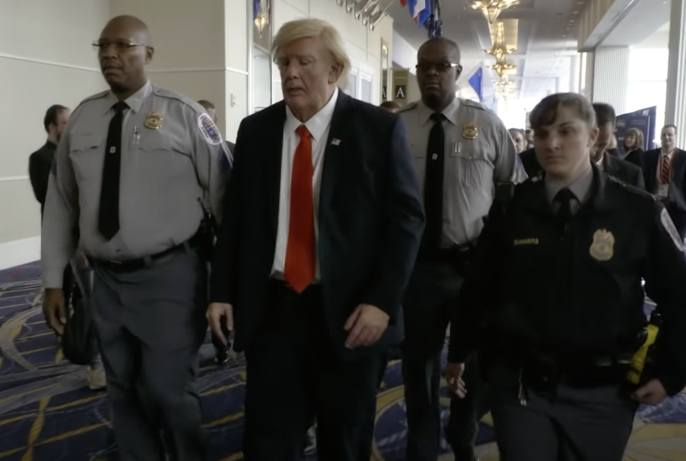 sacha baron cohen in disguise as donald trump getting escorted by police