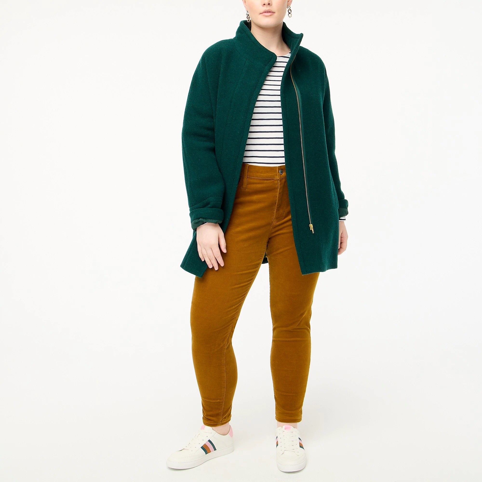 model in dark green zip-up upper thigh-length coat