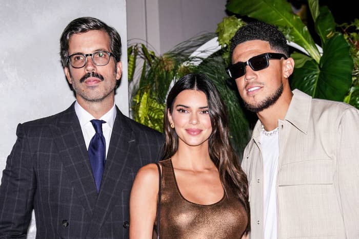 Devin and Kendall posing for a photo with a man in a suit and tie