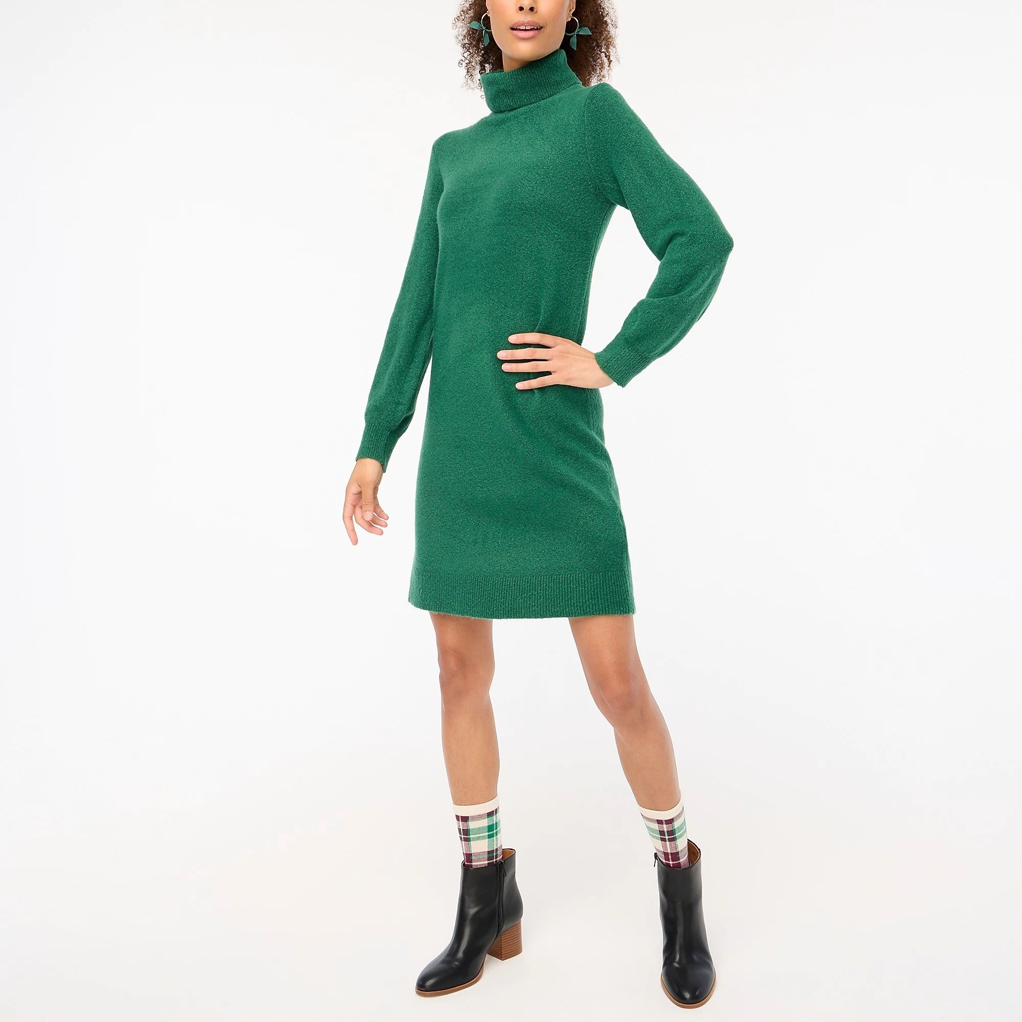 model in green mid-thigh length turtleneck long sleeved dress