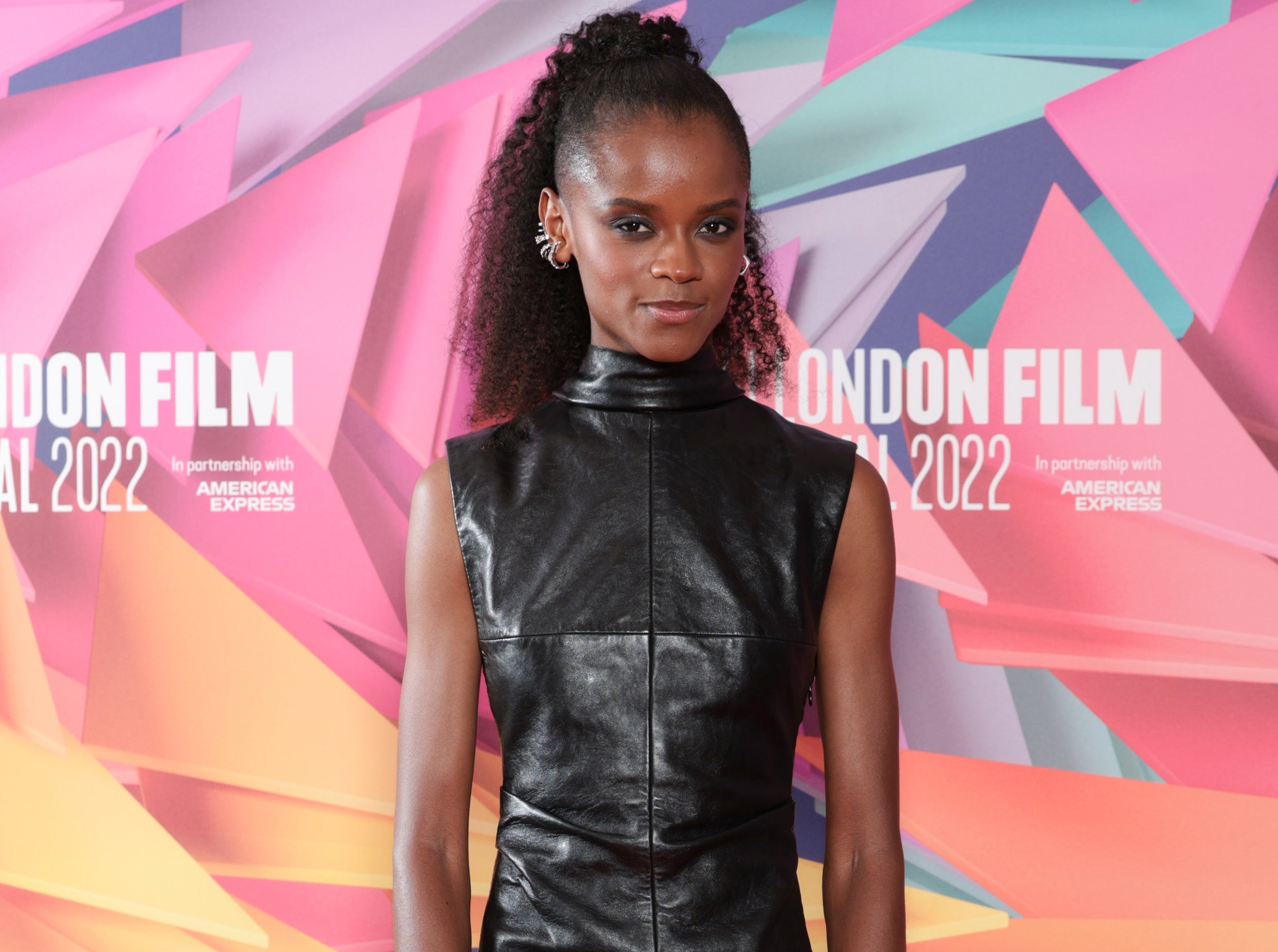 A close-up of Letitia in a sleeveless leather turtleneck outfit on the red carpet