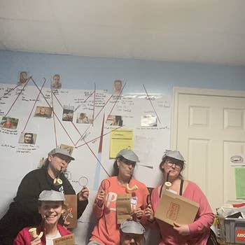 Five reviewers with hats and pipes in front of the board with their case information