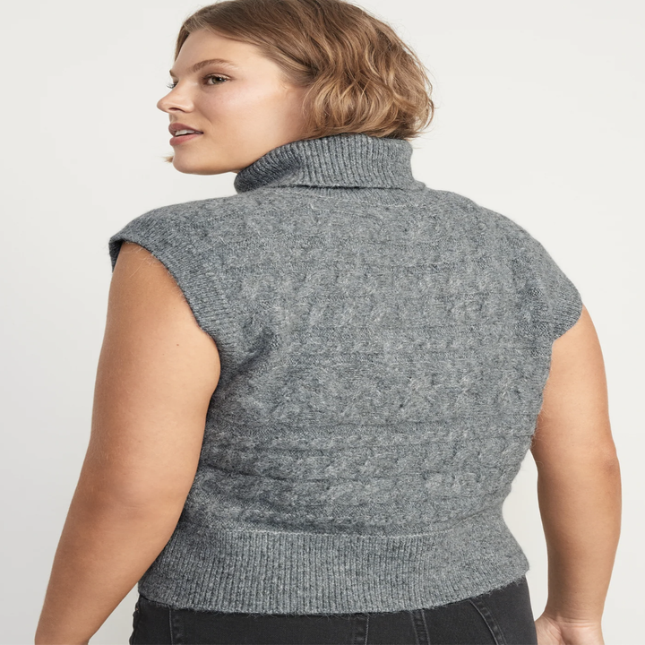 A person showing off the back of the sweater vest