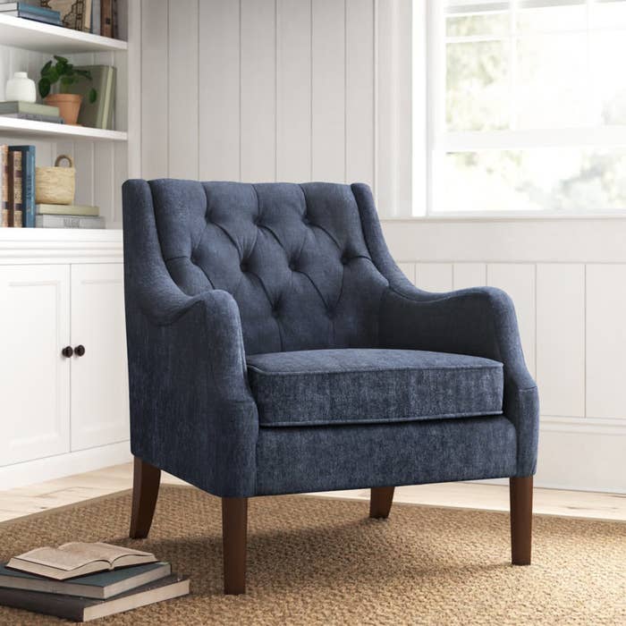 a dark blue upholstered wingback armchair