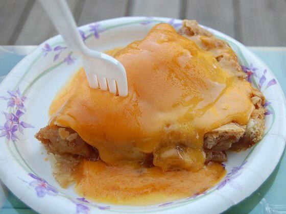 Cheese melted on a slice of apple pie.