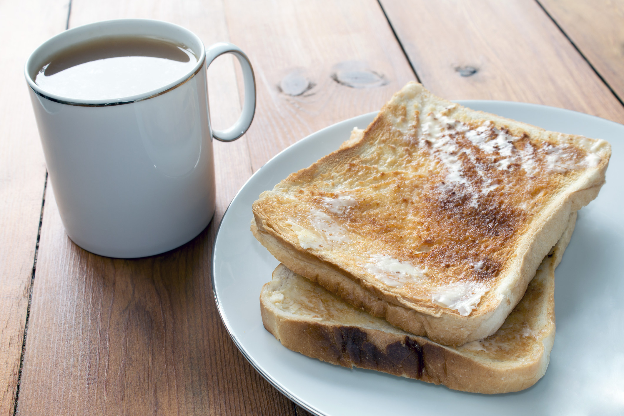 Tea and toast on a rustic wooden table.