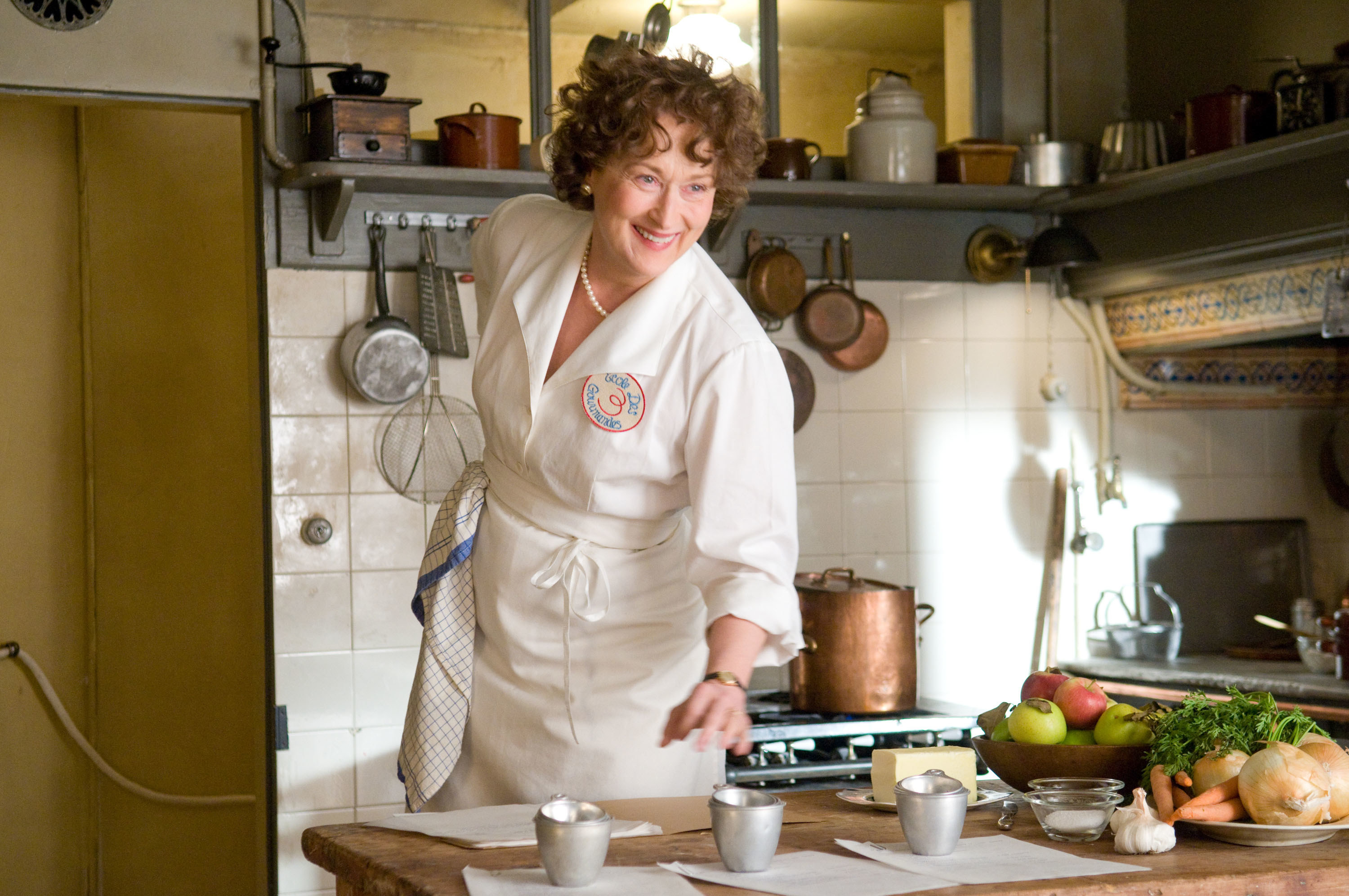 Meryl Streep stands in a kitchen cooking