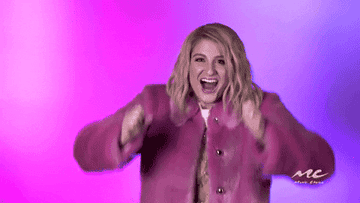 Meghan Trainor reaching her hands out in a grabby motion