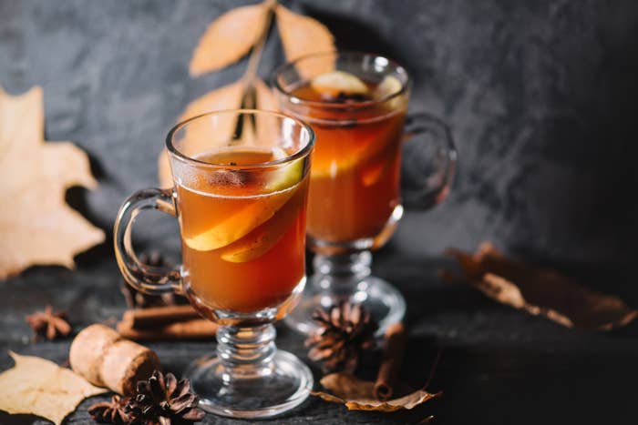 Two glasses of hot apple cider with cinnamon and anise