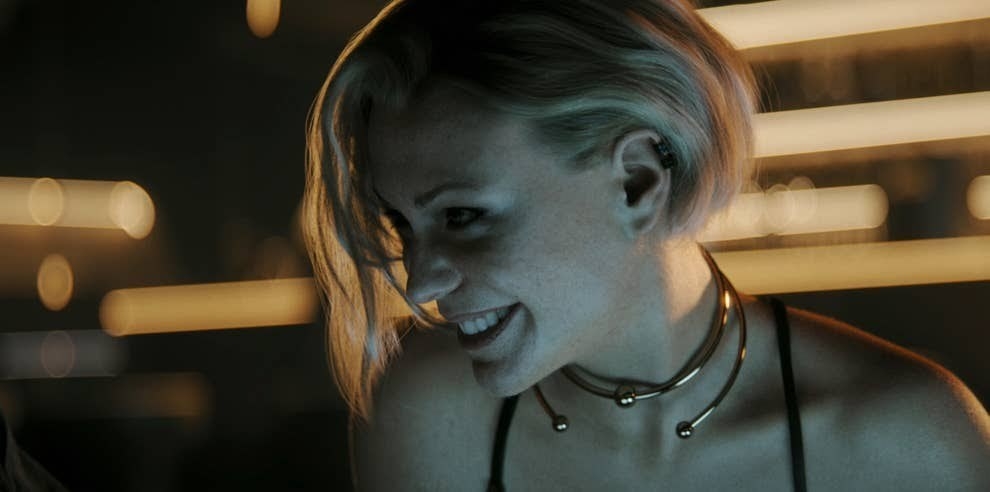 A woman in uniquely futuristic jewelry smiles at her companion