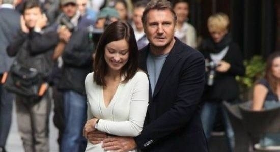 Olivia Wilde and Liam Neeson smiling and walking