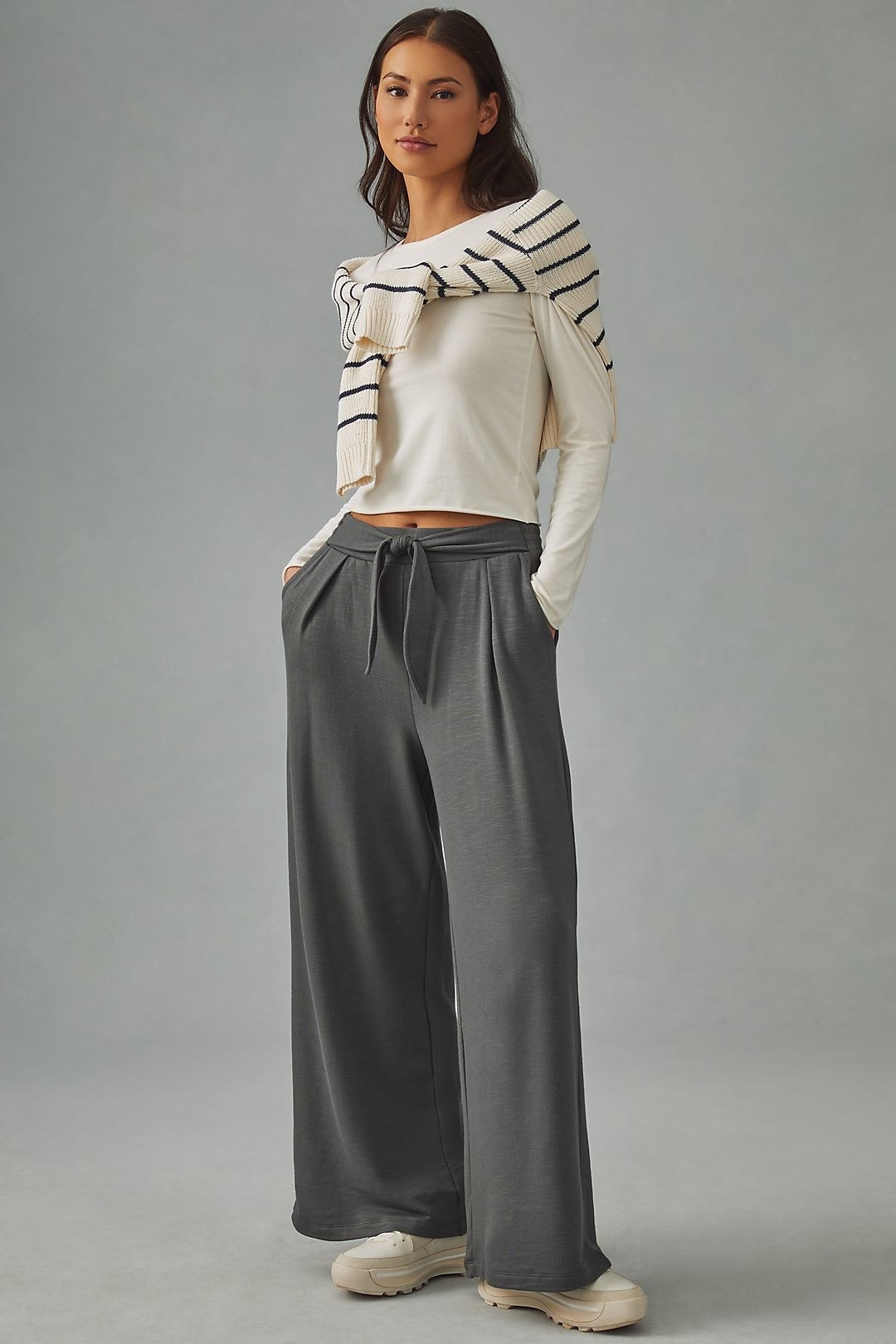 model in wide-legged grey pants with a short tie at the waist