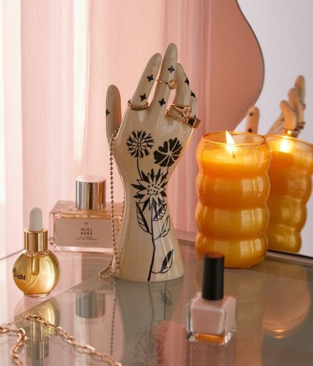 a hand-shaped jewellery stand on a vanity