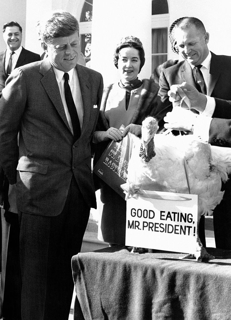 kennedy with the turkey and its sign that reads good eating, mr. president